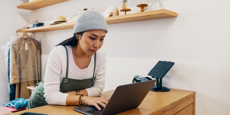 A small business owner working on a laptop to track business expenses and manage cash flow efficiently.
