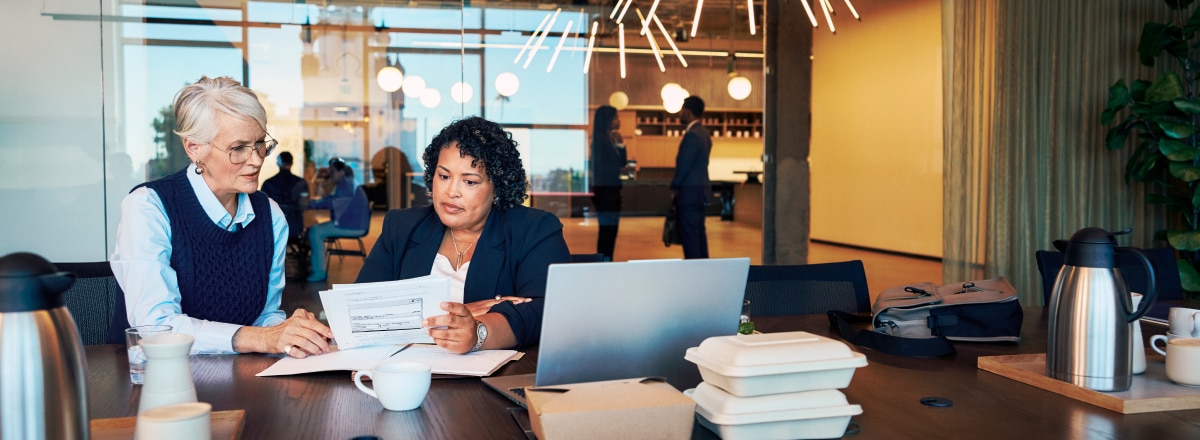 Two people at conference table reviewing documents