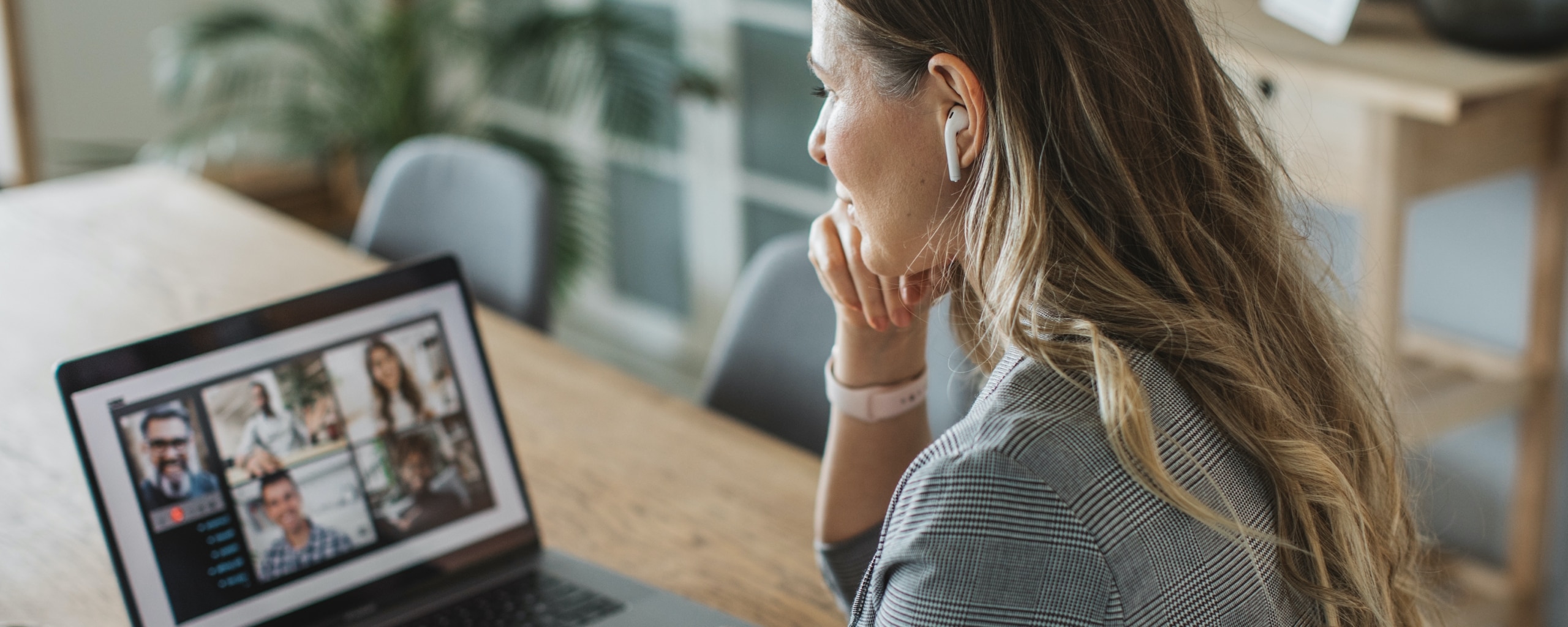 Woman sitting at a table on a video conference call on her laptop.