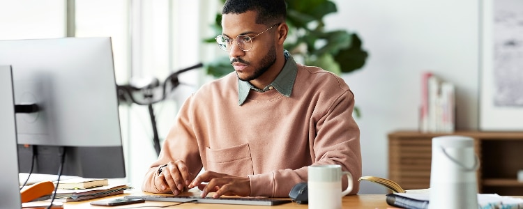 Business owner sitting behind a desk working on his computer.