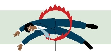 Individual wearing a business suit diving through a flaming hoop.