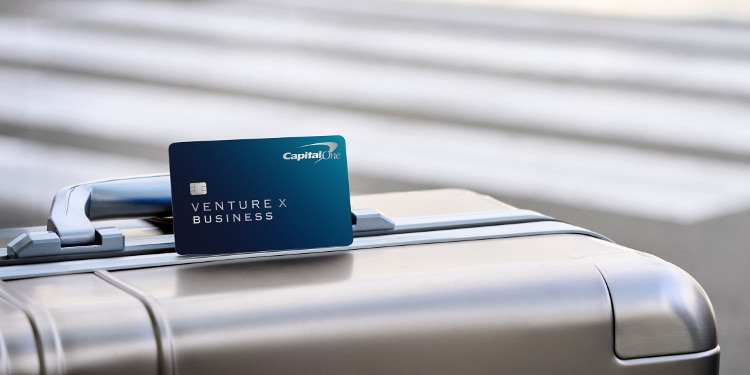Venture X Business card sitting on top of a suitcase.