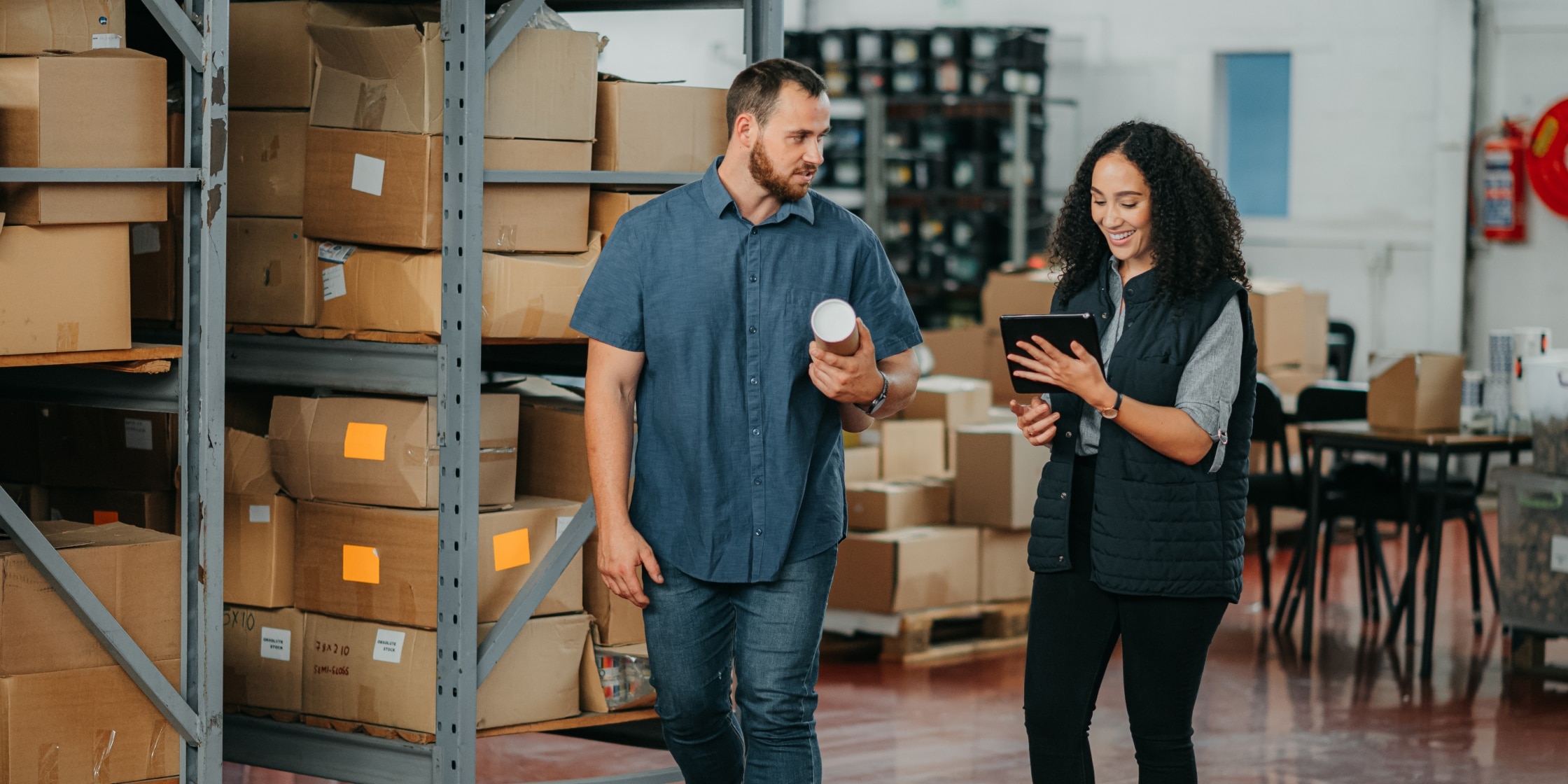 A factory or logistics manager talking in a warehouse, managing corporate purchasing and P-card expenses.