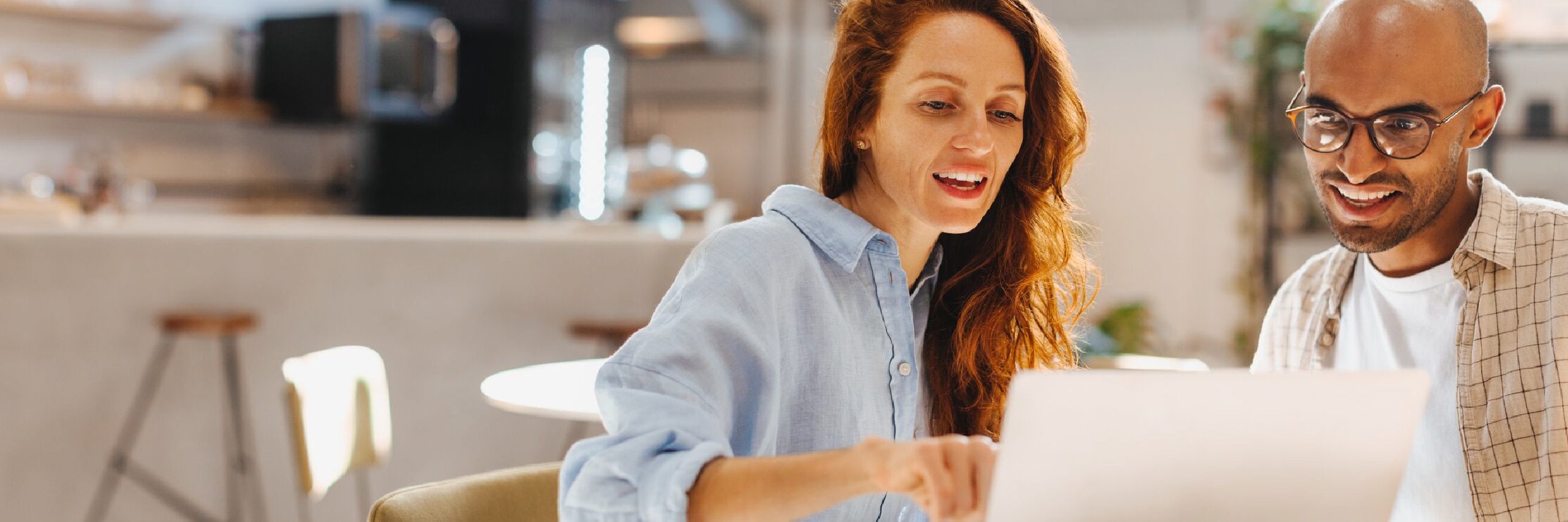 Woman and man pointing at laptop