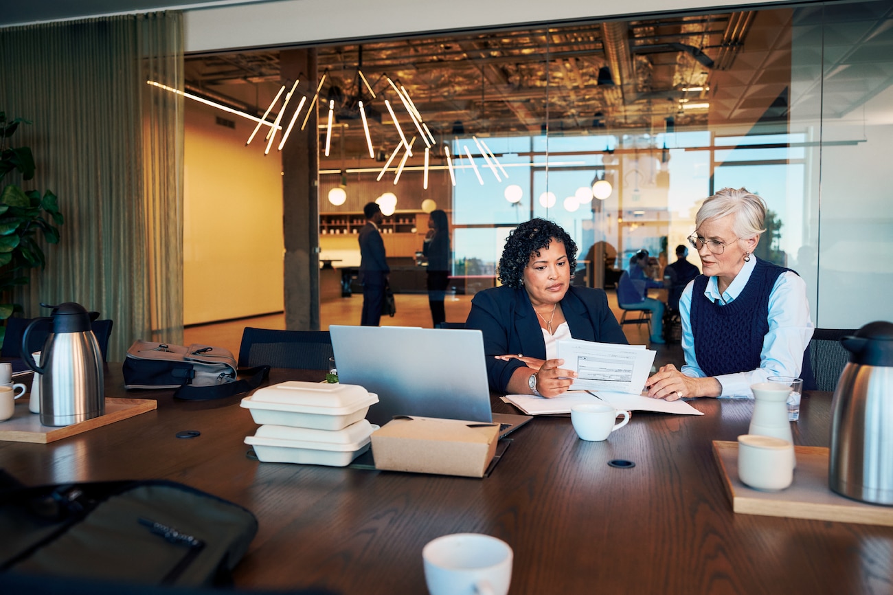 Two women sitting at a table looking at documents