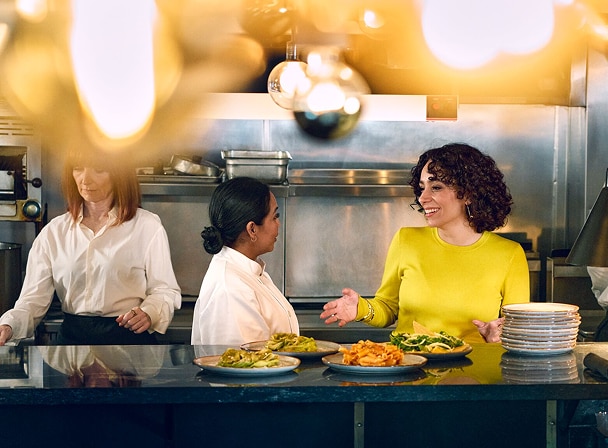 Woman greeting chef in kitchen