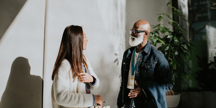 Man and woman speak to each other outside of conference