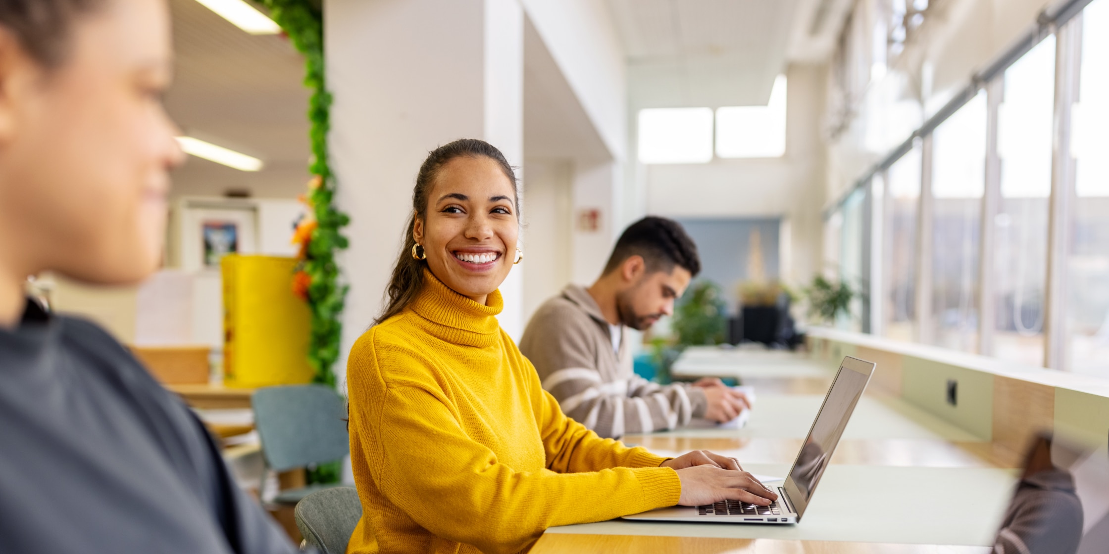 Student on laptop laughs with peers