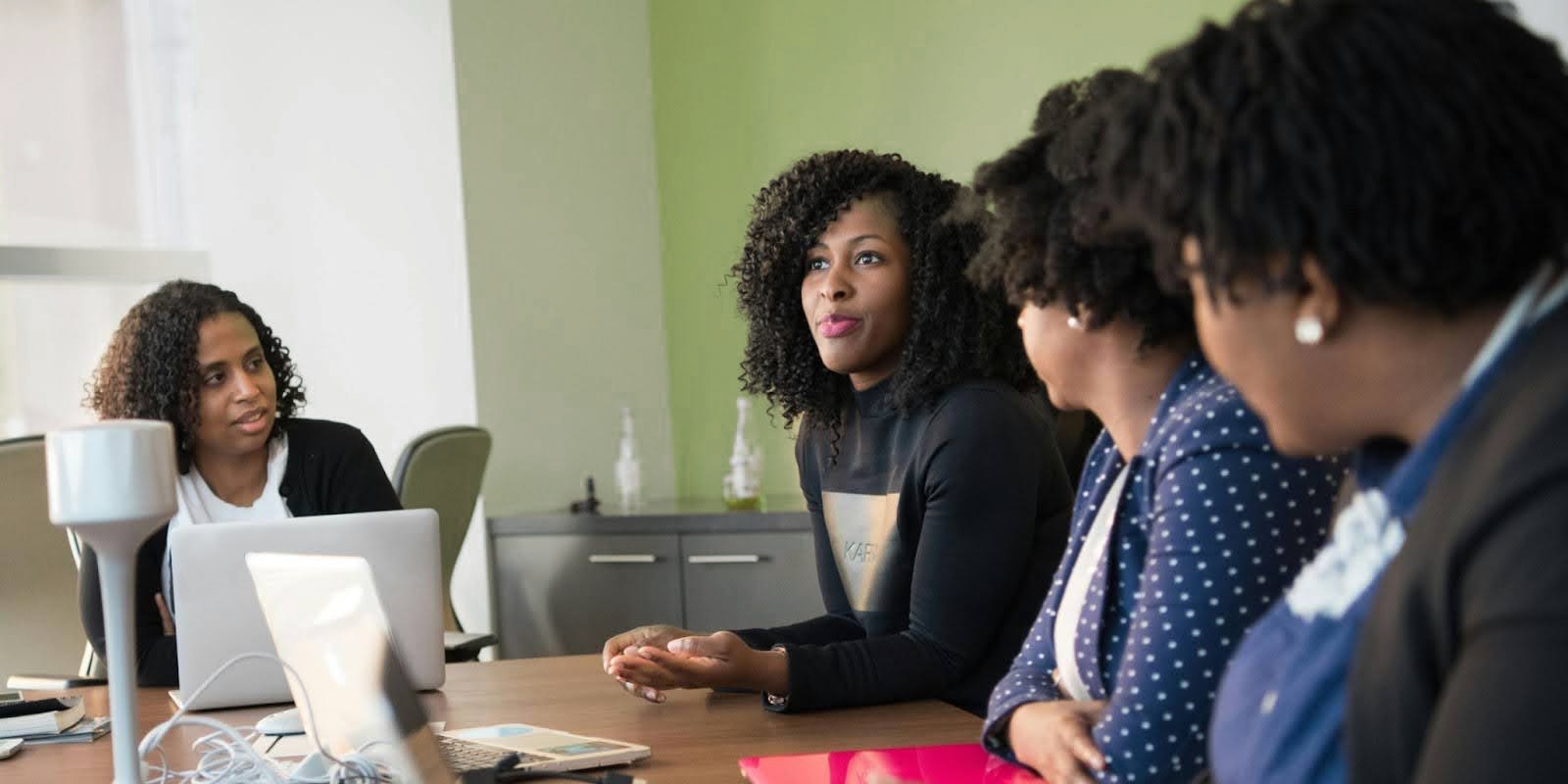 Colleagues working at a table together with laptops