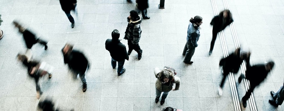 overhead view of blurred people walking through a plaza