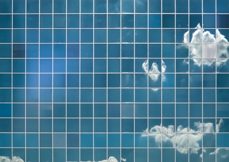 skyscraper windows with cloudy sky reflecting through