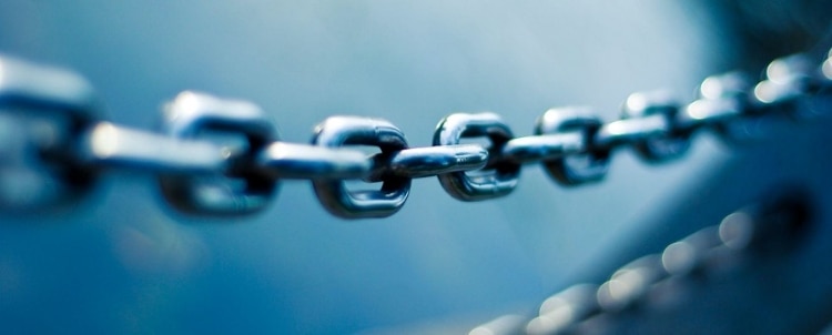 Soft focus image of a sturdy metal chain in cool tones of blue and grey
