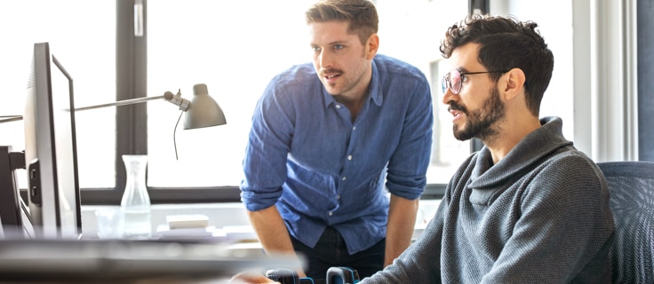 two technologists sitting at a computer