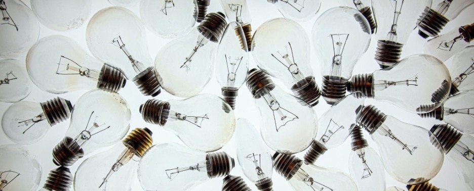 overlapping clear lightbulbs set against a brilliant white backdrop
