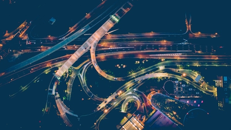 aerial shot of highway lit up with green blue and red lights