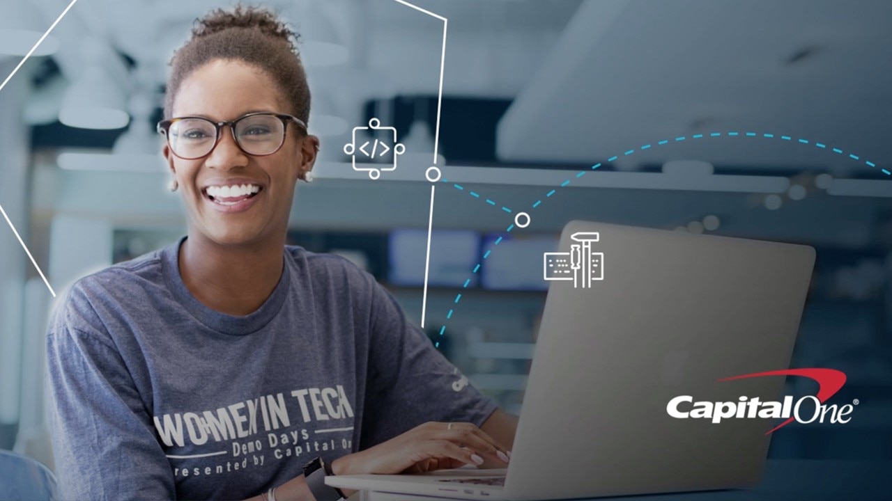 capital one associate smiling and wearing purple women in tech tshirt and using silver computer. white signs and </> icons and dotted circle and hexagon overlayed, with capital one logo in corner