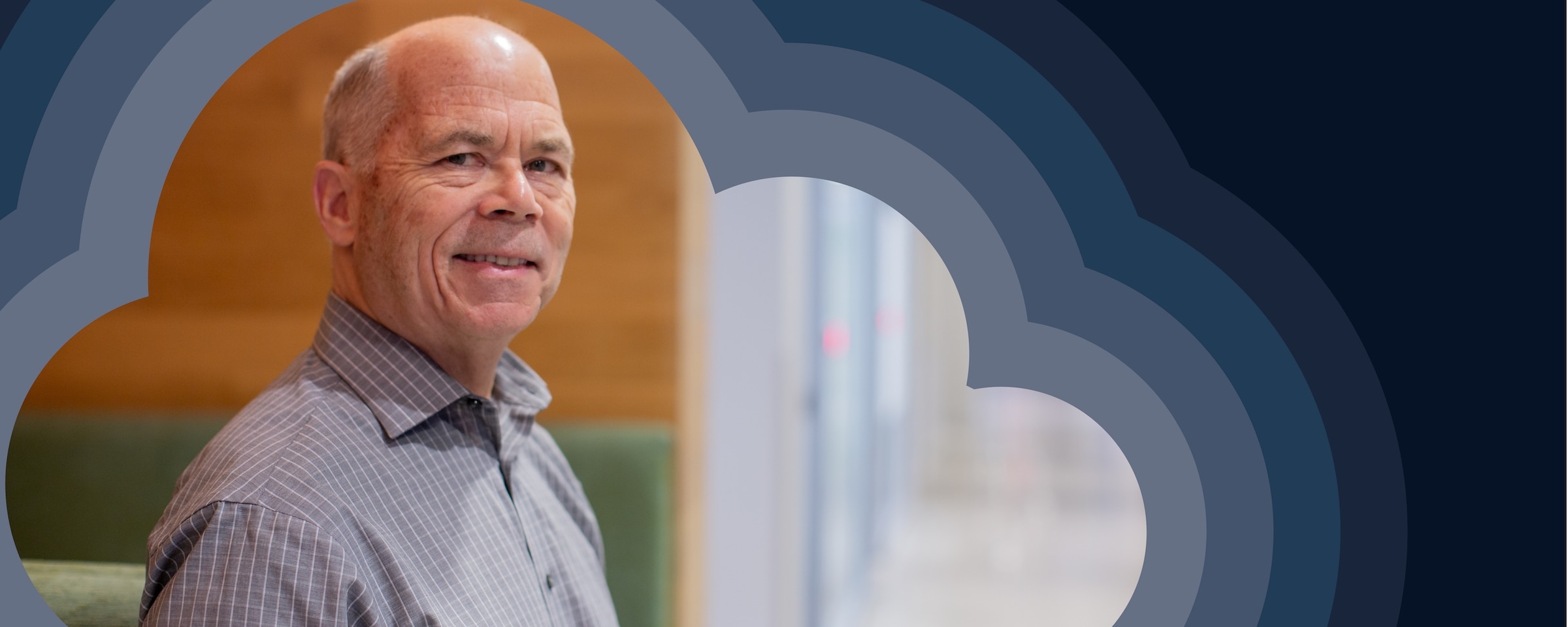 photo of Bernard Golden standing in front of grey and navy concentric clouds.