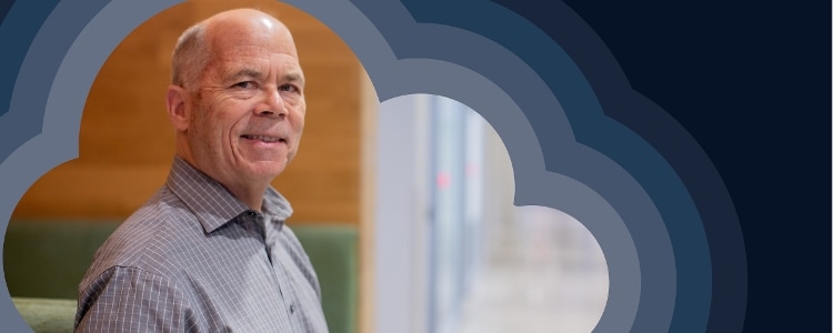 photo of Bernard Golden standing in front of grey and navy concentric clouds.