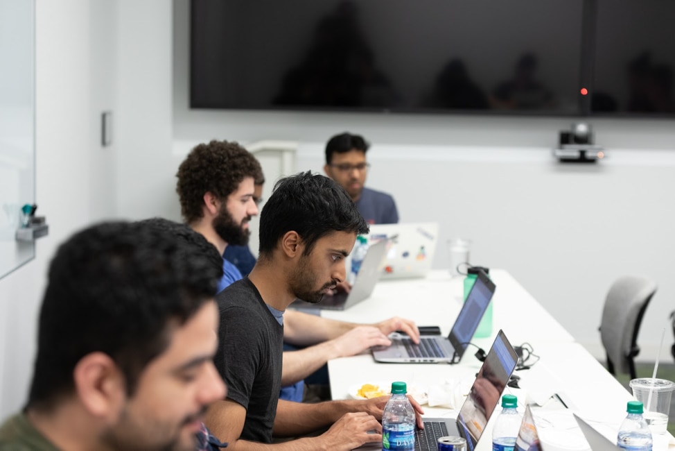 4 developers at a Hackathon focused on their computers