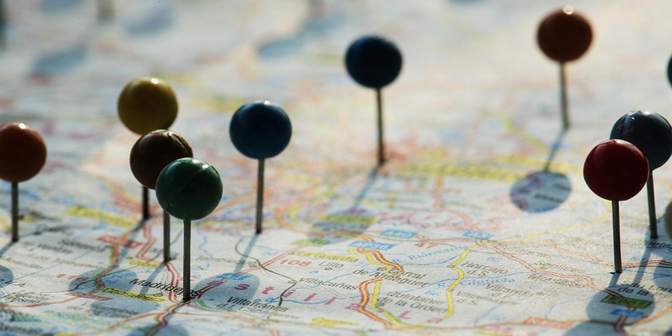 Push pins with circular tops pushed into various points on a map