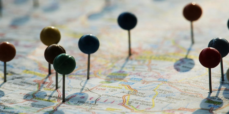 Push pins with circular tops pushed into various points on a map