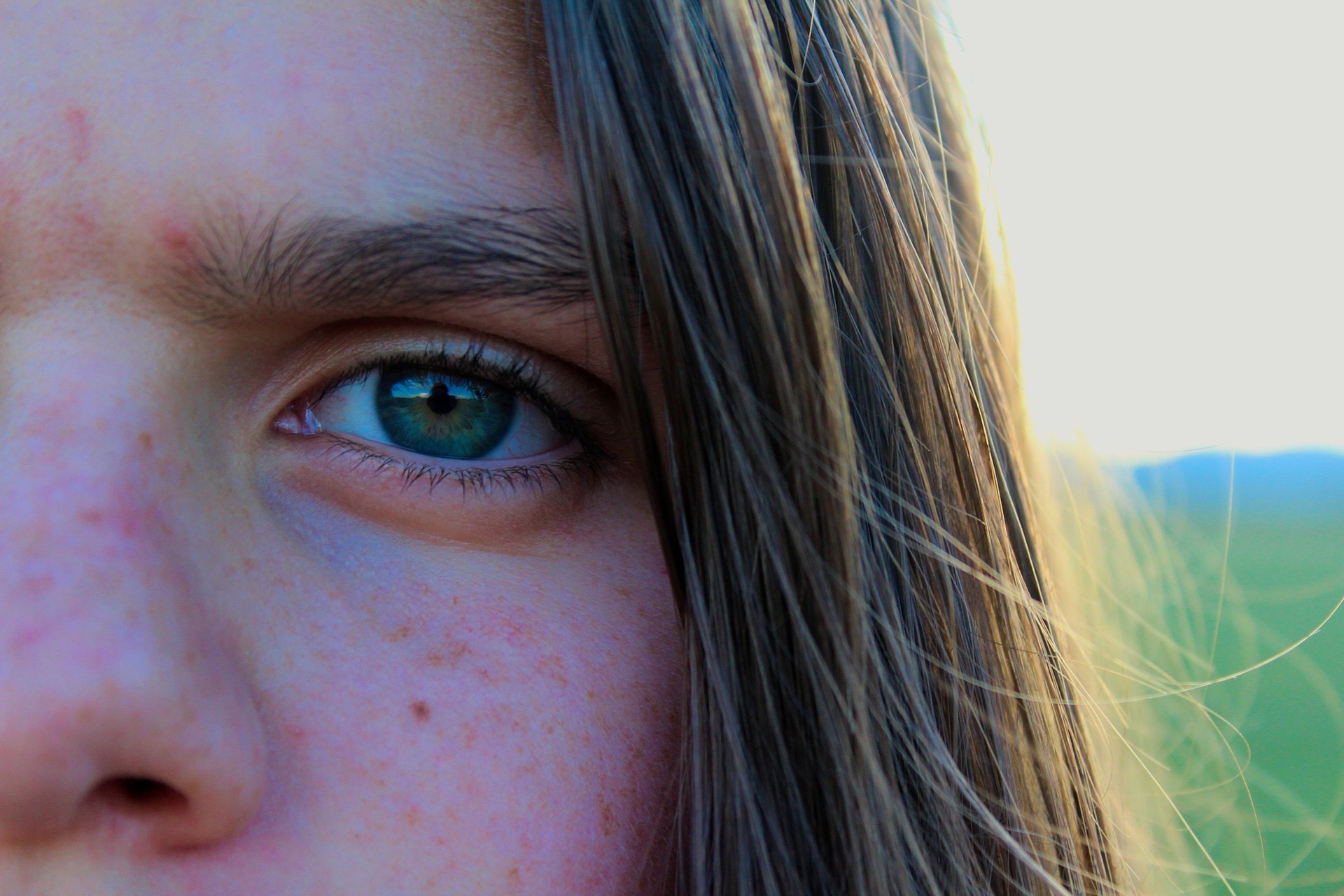 close up of a human face with a green eye