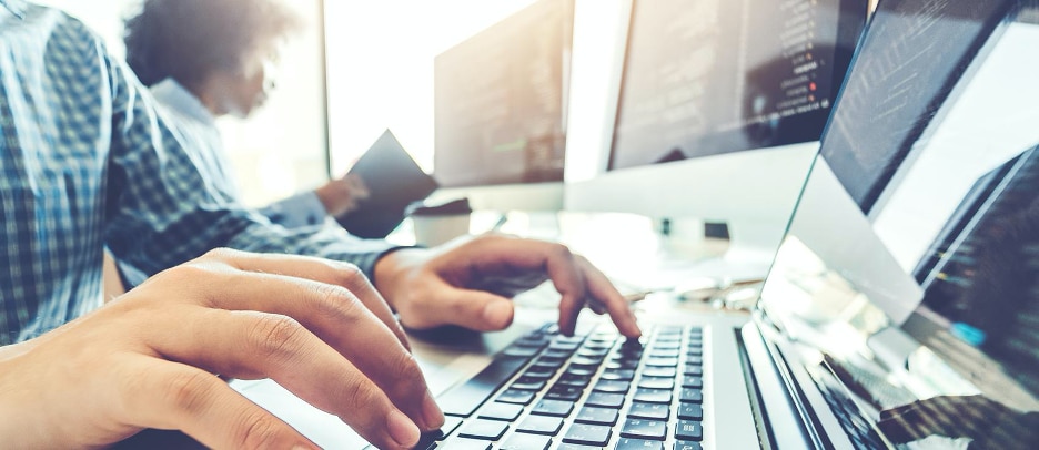 close up of mans hands typing over a laptop keyboard