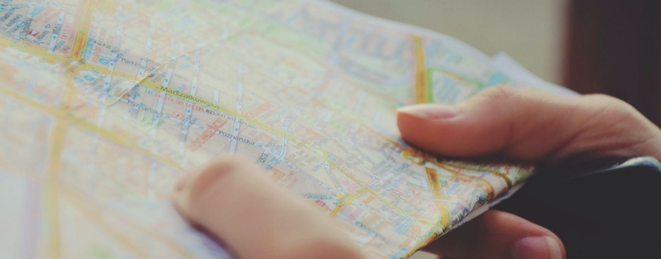 close cropped photo of someone holding an old fashioned road map in their hands